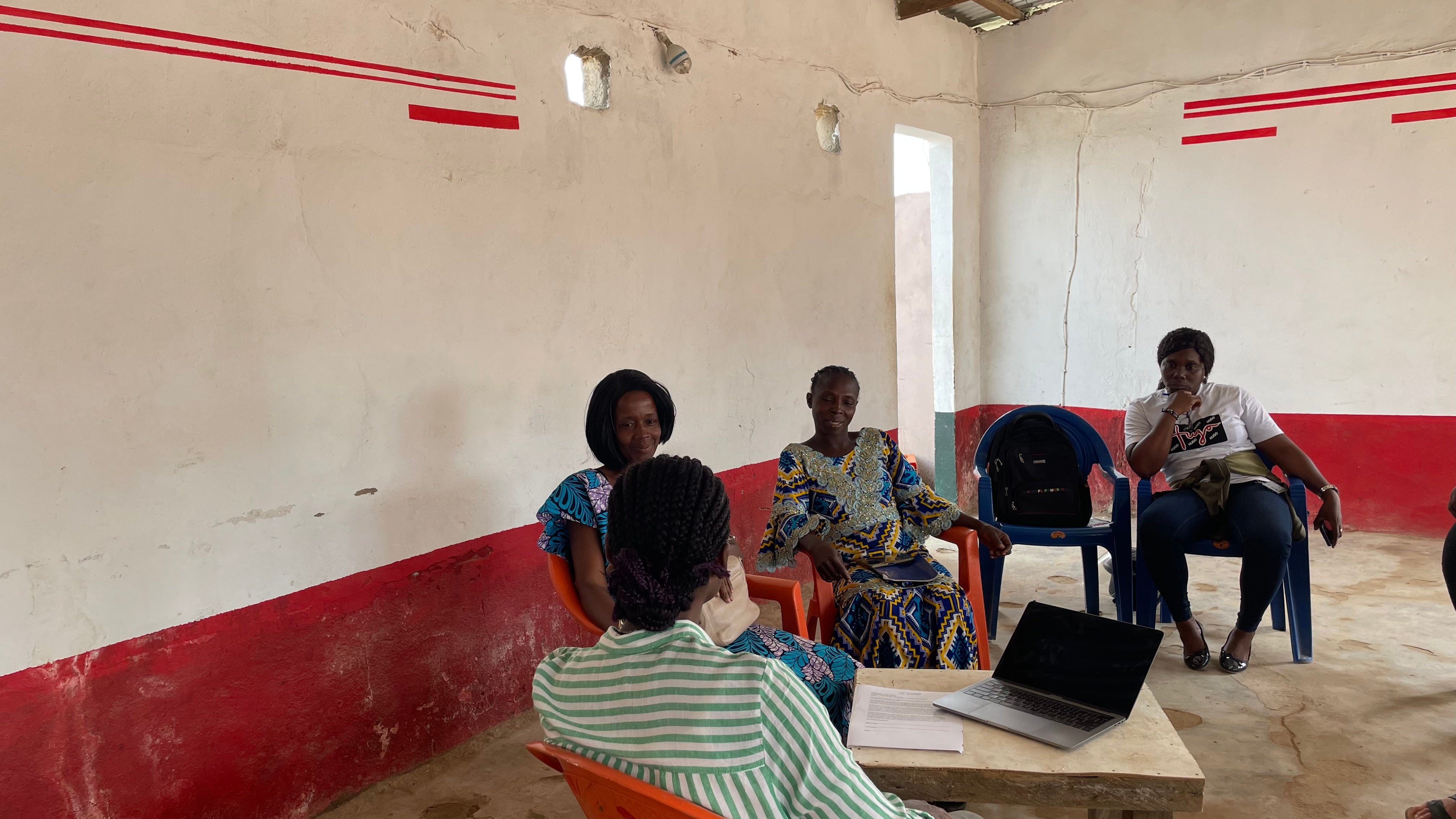 Women meet in a room with plastic chairs