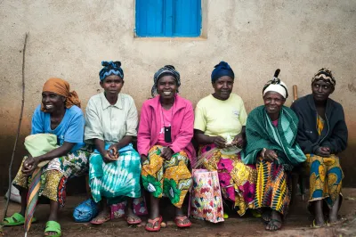 Women wait to receive planting supplies including hybrid seed and fertilizer they purchased on credit from a social enterprise called One Acre Fund, Rwanda