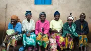 Women wait to receive planting supplies including hybrid seed and fertilizer they purchased on credit from a social enterprise called One Acre Fund, Rwanda
