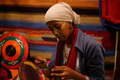 a woman in a headscarf is threading a needle