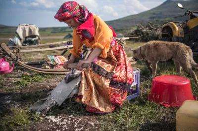 A woman works an animal hide