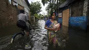 People move through a flooded street during monsoon season