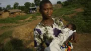 A young African woman holds a baby