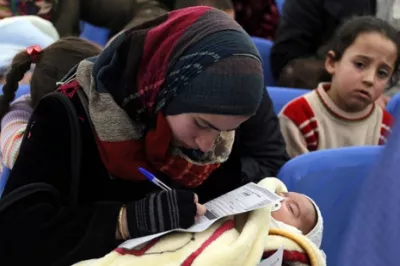 A refugee filling an application at the UNHCR registration center in Tripoli, Lebanon. Photo by Mohamed Azakir, World Bank.