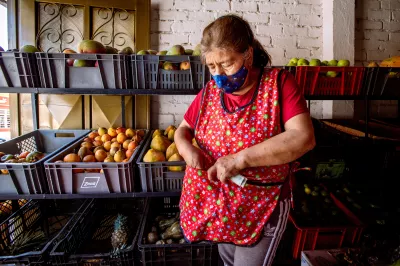 a female shopkeeper places cash in her apron pocket