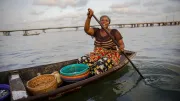 A woman paddles a boat full of goods