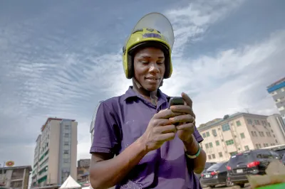 A young motorbike driver looks at his smartphone