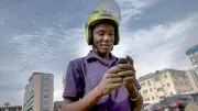 A young motorbike driver looks at his smartphone