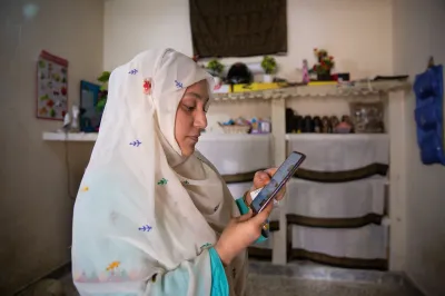 A woman shop owner looks at her smartphone