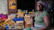 A woman sits among food goods in her corner shop in Lagos, Nigeria
