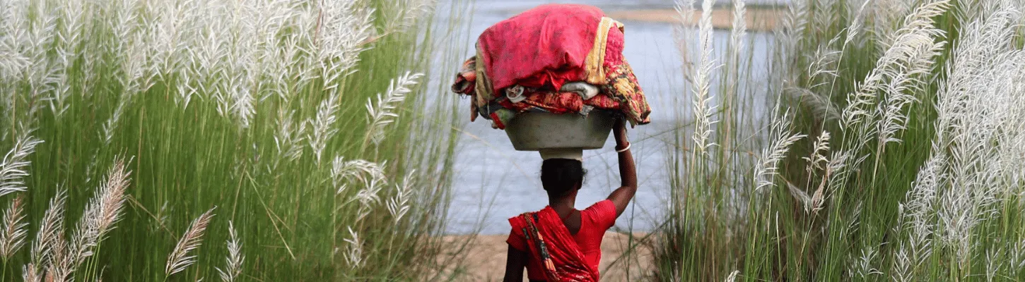 woman carrying basket on head in field