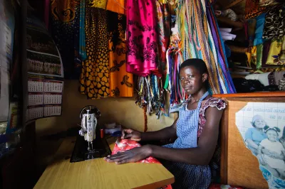 A young woman sits by her sewing machine
