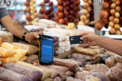 a man making a payment using a credit card machine at a street market