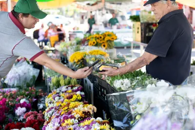 A man pays via mobile money at a market in Brazil