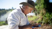 A Brazilian farmer looks at his phone