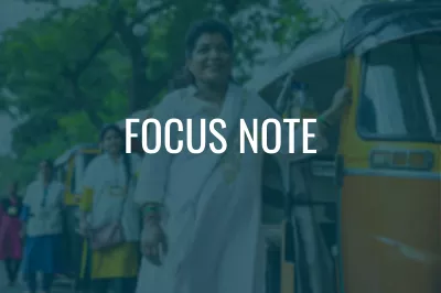 a smiling woman standing  by a rickshaw