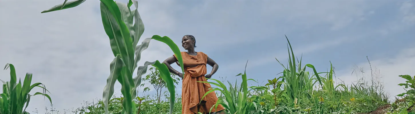 an african woman standing in a field with her hands on her hips