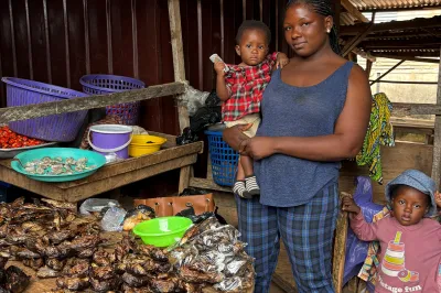 A woman and her children stand in a doorway