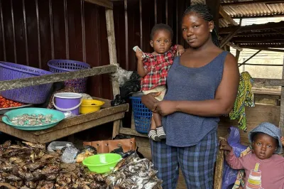 a woman stands in front of a table of foods with her two children