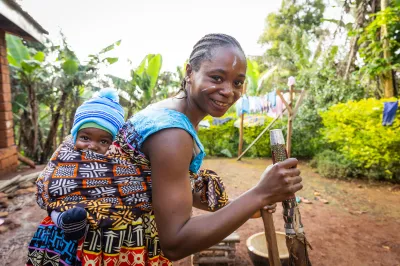 A smiling African mother with her newborn baby in tribal clothing