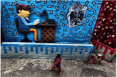 a pedestrian viewing street art depicting a desk worker