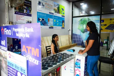 a woman sitting behind a desk with a digital payment reader