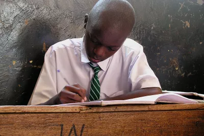 A primary school student at his desk in Kampala, Uganda