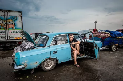 A fruit vendor sits in his car